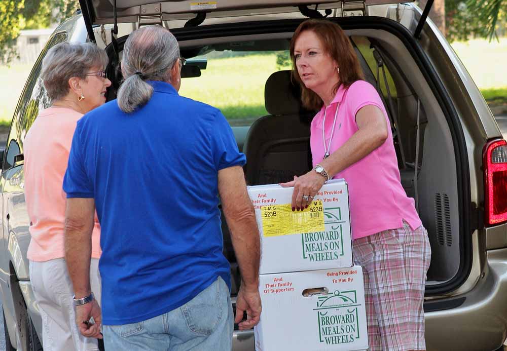 Tamarac Volunteer Lisa Mattson passing out Meals on Wheels boxes to those on her route.