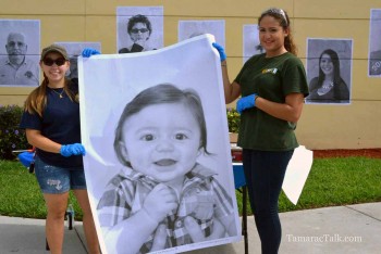 BSO Explorers and JP Taravella Students Rita Lucas and Daniela Gallego hold up the photo of the youngest participant. 