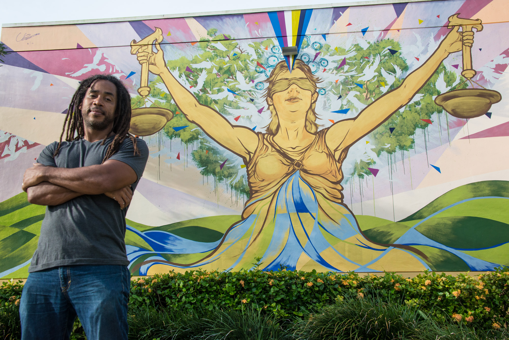 Ruben Ubiera in front of his mural "Lady Justice" - Photo by Sharon Aron Baron