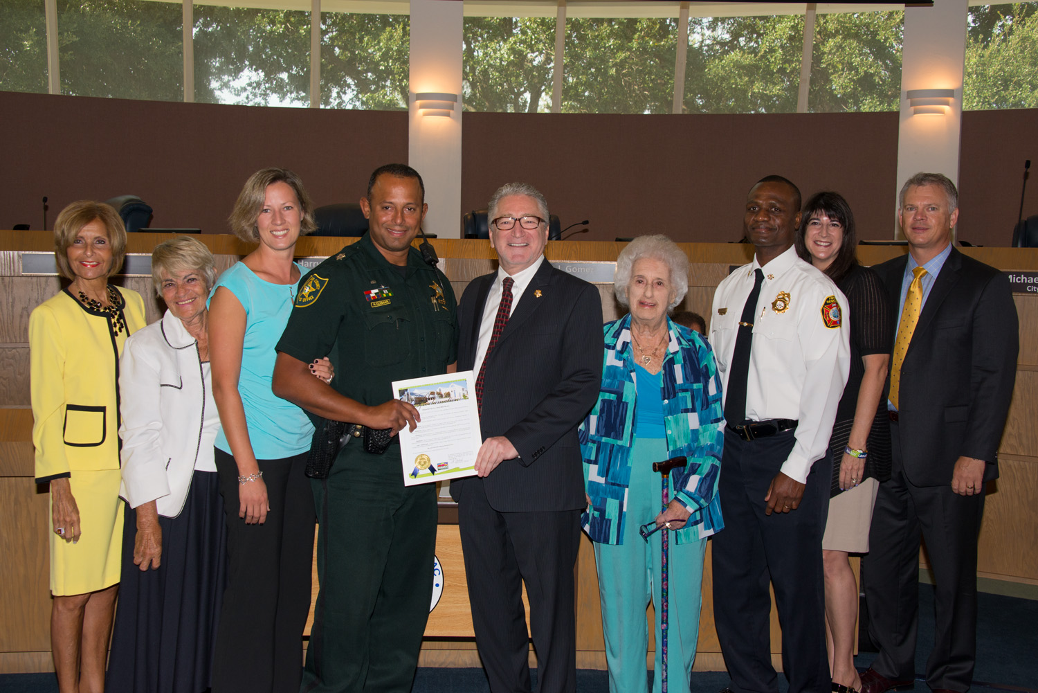 BSO Deputy Henry Guzman is issued a proclamation by the Mayor and City Commission.  His wife is to his left. 